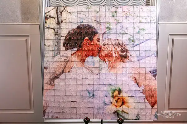 Interactive Mosaic Photo Wall at a LGBT wedding reception featuring various images of the happy couple and their guests, creating a visually stunning display. The photo wall serves as both entertainment and a sentimental keepsake, displaying a heartwarming message from the couple prominently in the center of the mosaic.