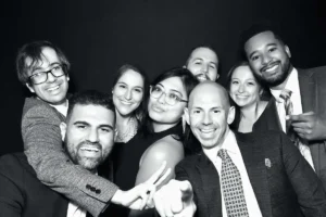 A lively group of guests making exaggerated fun expressions in black and white at Milestone NJ.