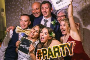 A group of friends posing at a photobooth - Milestone Photo Booths.