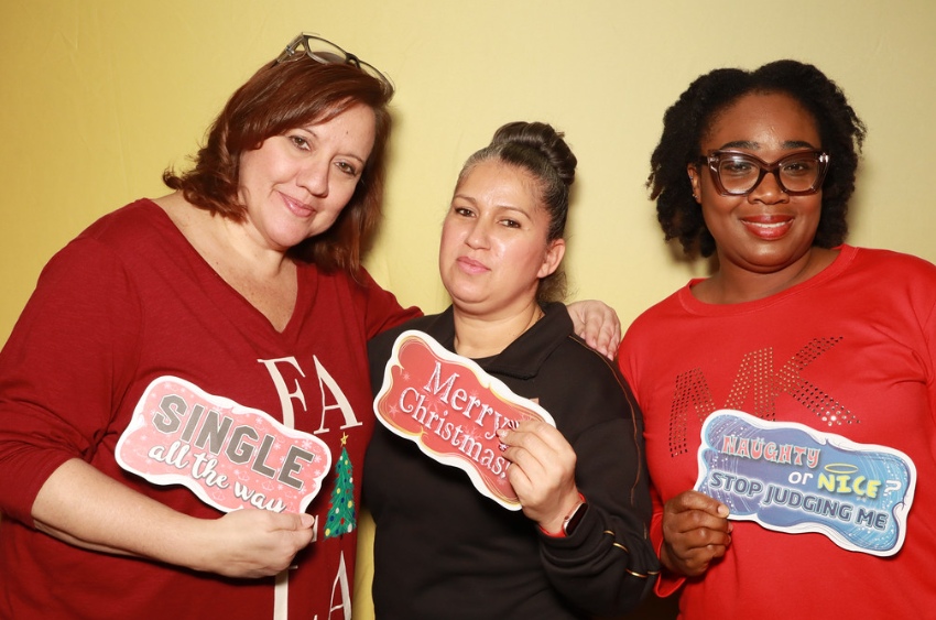 A joyful trio photo holding up festive signs at Milestone NJ.