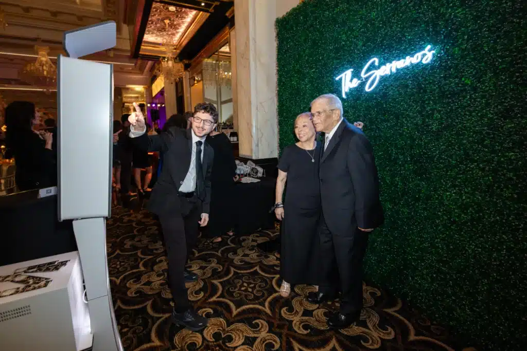 Wedding guests using a modern photo booth at a reception creating fun memories