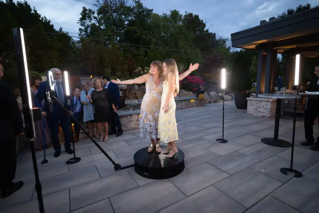 Guests using a 360 photo booth at a wedding capturing dynamic video experience