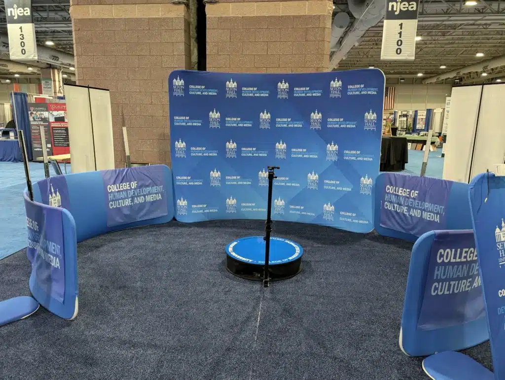Branded 360 video booth setup at trade show with custom backdrop for corporate event engagement and brand activation