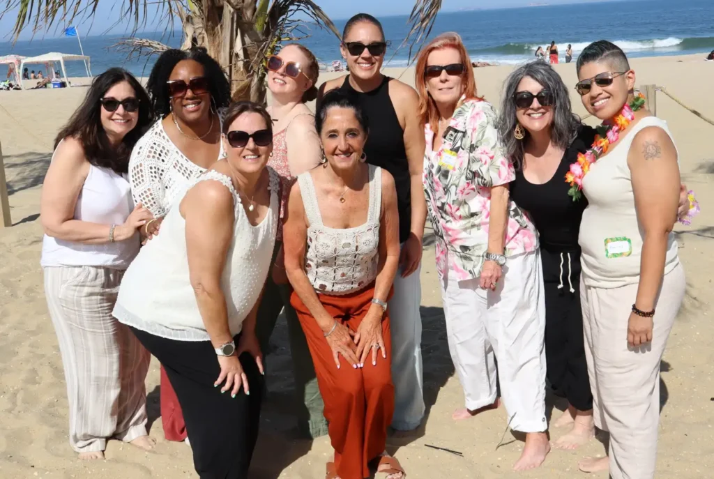 A group of guests smiles under a palm tree for the Roamer Pro roaming photo booth at the Neurosurgeons of NJ Beach Party