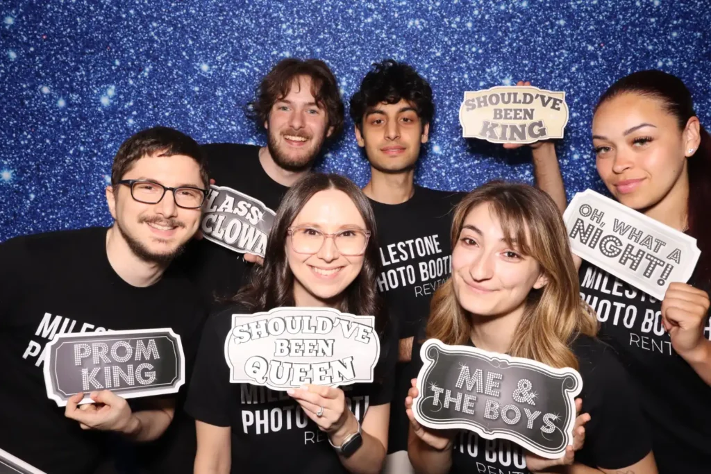 Milestone team posing with props in the Traditional Photo Booth against a starry blue backdrop at MTHS Senior Prom, NJ prom photo booth rental